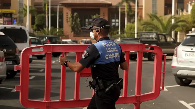 A Spanish police officer sets a barrier blocking the access to the H10 Costa Adeje Palace hotel