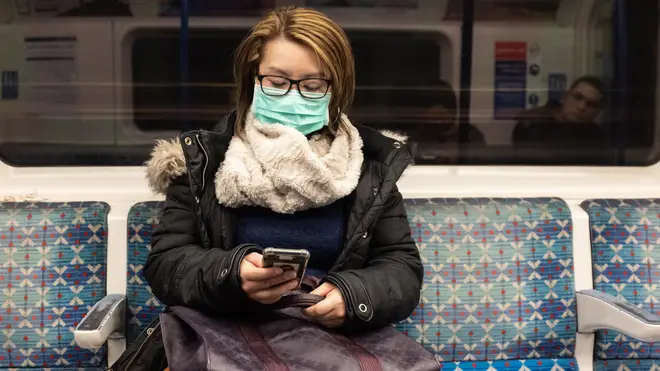 A woman wears a mask on the tube in London