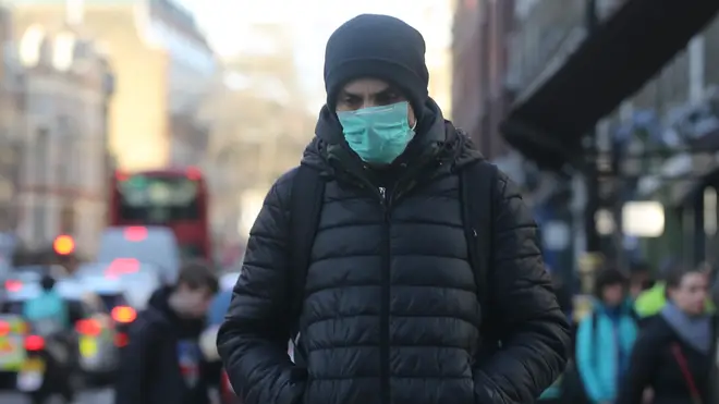 A man walks in a protective mask in London