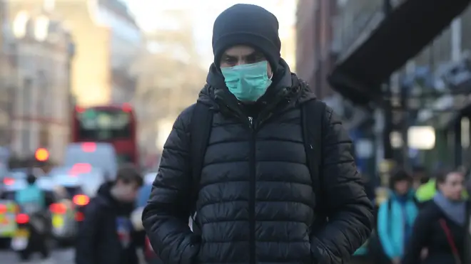 A man wears a face mask on a street in London