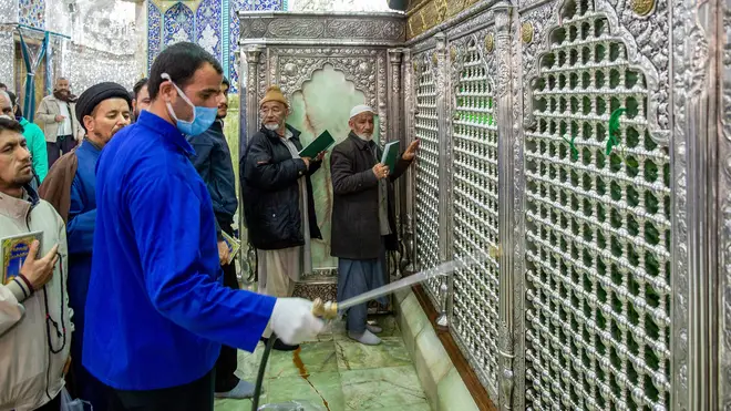 A man disinfects the shrine of Saint Masoumeh against coronavirus
