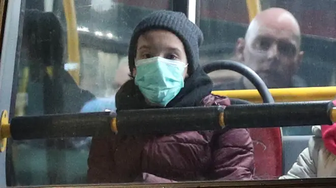 A person travels on a London bus in a coronavirus mask
