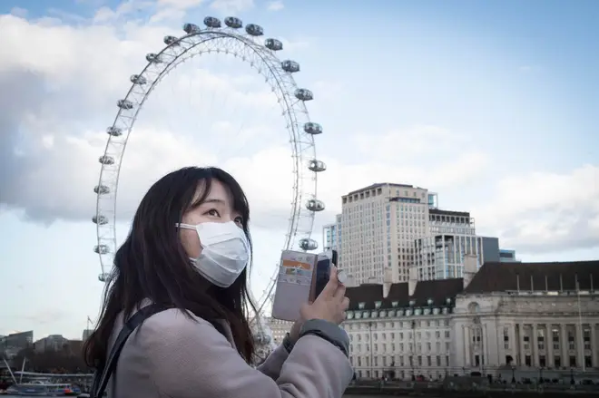 A woman wears a facemask to protect herself in London