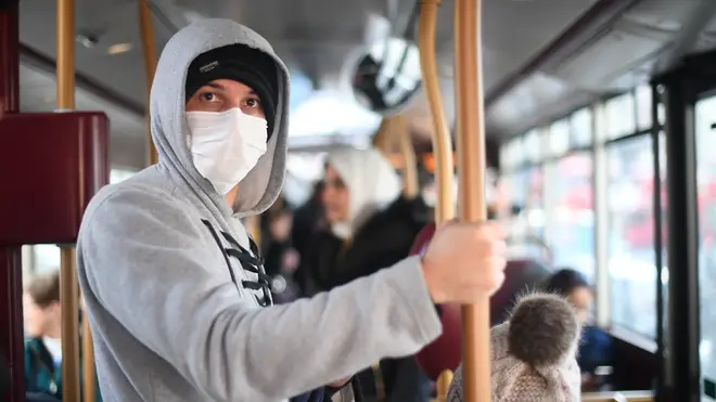 A man wears a mask on board public transport in London