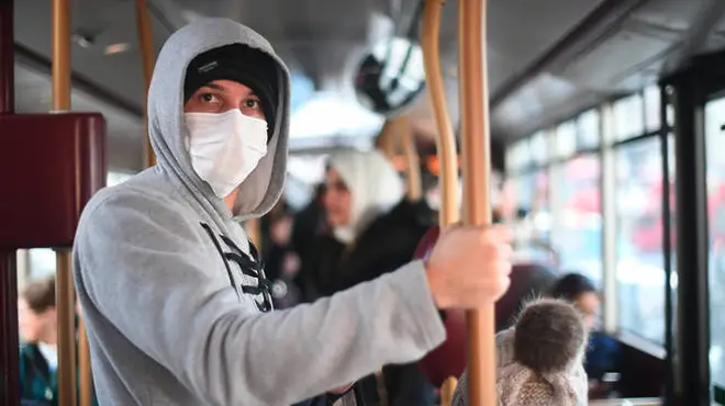 A man wears a mask on board public transport in London.