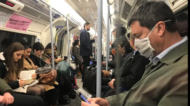 A man wears a coronavirus mask on the Tube