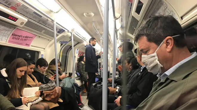 A man wears a coronavirus mask on the London underground