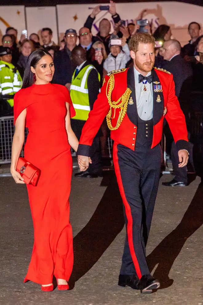 The duke wearing a Royal Marines officer's mess jacket and his wife wearing a red dress