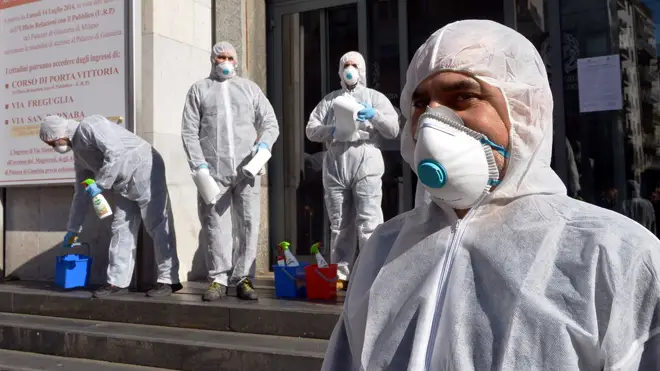 Workers carry out a coronavirus clean-up in Milan