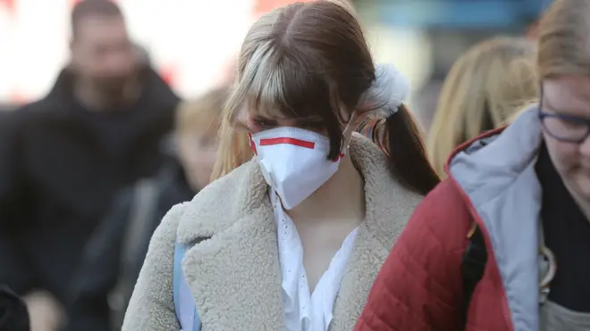 A woman wears a protective mask in a street in London