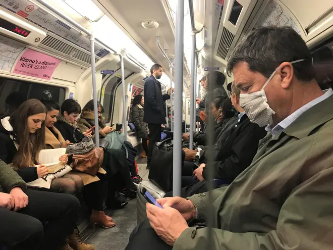 A London commuter wears an anti-Coronavirus mask