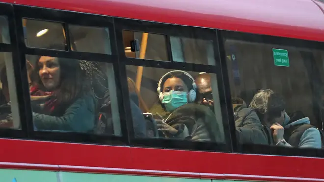 A woman in a protective mask on a London bus