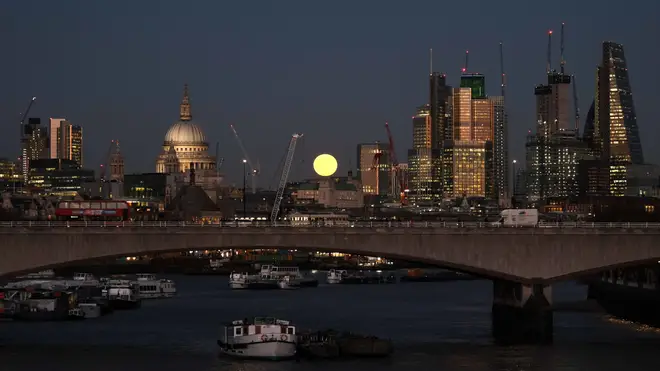A blue super moon rises over the City of London