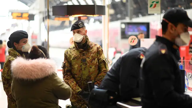 Italian soldiers with face masks are on duty at Milan Central Railway Station