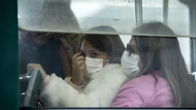 Two women wear face masks on a bus in Rome