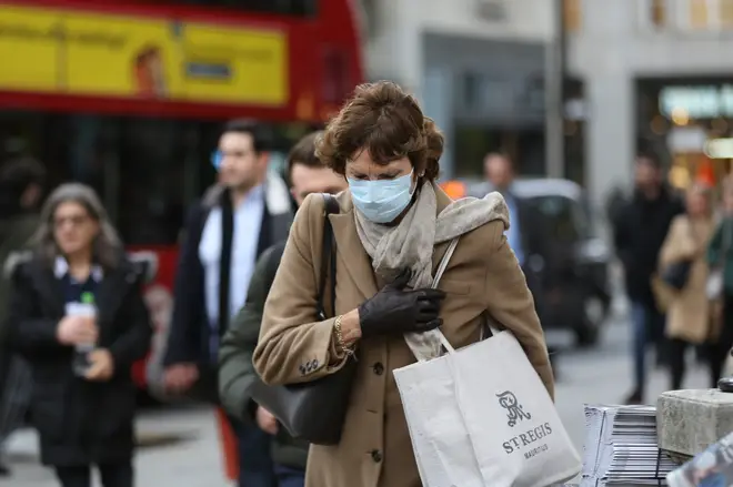 A woman in a protective mask walks in central London