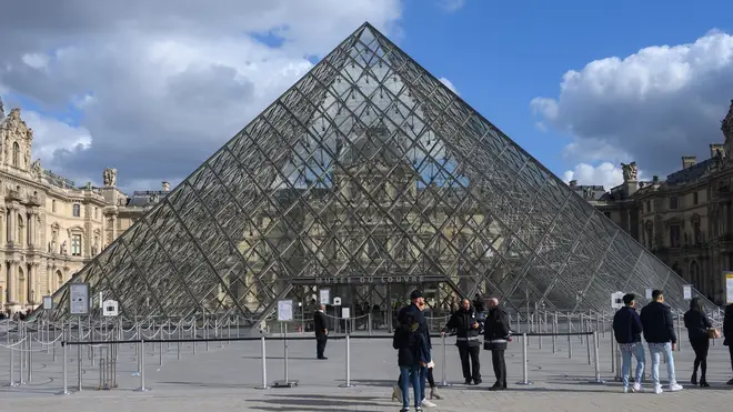 Tourists in front of the Musee du Louvre in Paris, undefinitely closed to the public amid concerns on the COVID-19 outbreak