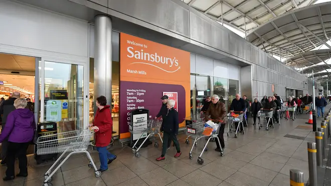 Shoppers queue outside a Sainsbury's supermarket prior to opening in Plymouth