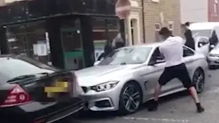 A group of men attack a BMW on a residential street