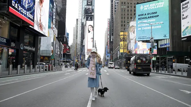 A woman stands in a virtually empty Time Square in New York
