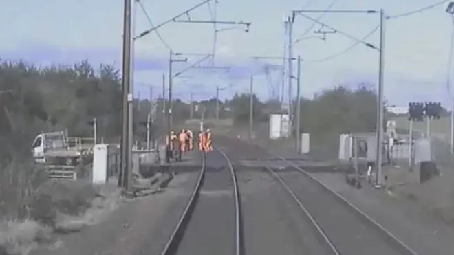 Workers scramble to safety as a train approaches