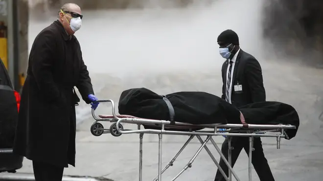 A funeral director wears personal protective equipment due to COVID-19 concerns while collecting a body at The Brooklyn Hospital Centre