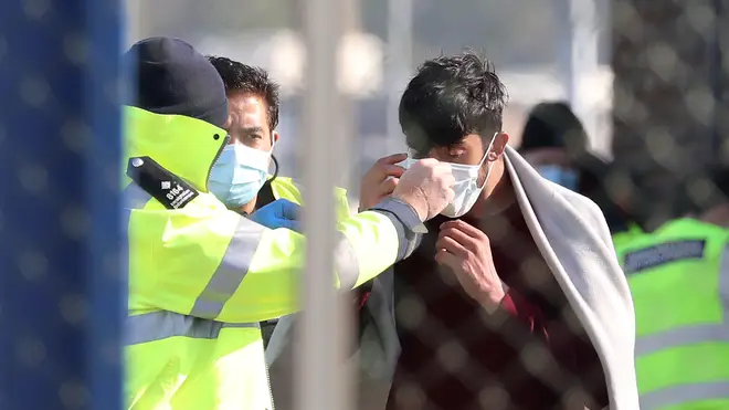 Border Force officers fit a mask to a suspected migrant