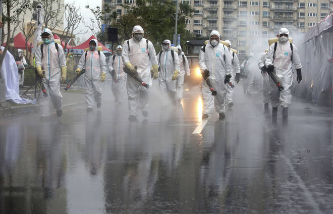 Army officers in Taiwan spraying disinfectant on the road surfaces