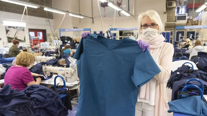 Fashion-Enter Ltd's factory production director Caroline Ash holds a medical uniform top produced for the NHS