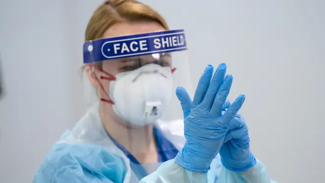 A member of staff receives training on how to put on and remove PPE, personal protective equipment (file image)