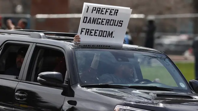 One person holding a card saying 'I Prefer Dangerous Freedom'
