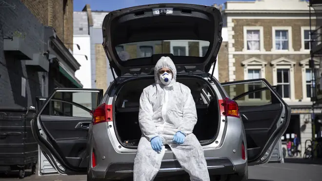 Uber driver Yasar Gorur wears personal protective equipment while cleaning his vehicle