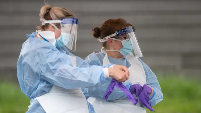 File photo: NHS staff put on personal protective equipment before carrying out Coronavirus tests at a testing facility in Bracebridge Heath, Lincoln