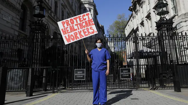 Doctor Meenal Viz holds a banner as she protests outside Downing Street in London, as the country is in lockdown to help curb the spread of the coronavirus,