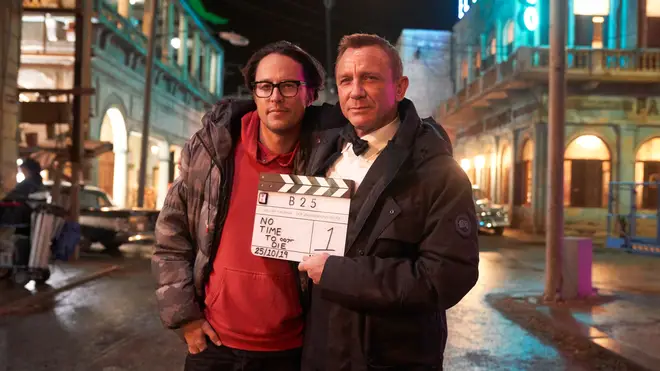Daniel Craig (right) holding a signed clapperboard for No Time To Die, which went under the hammer to raise money for the NHS