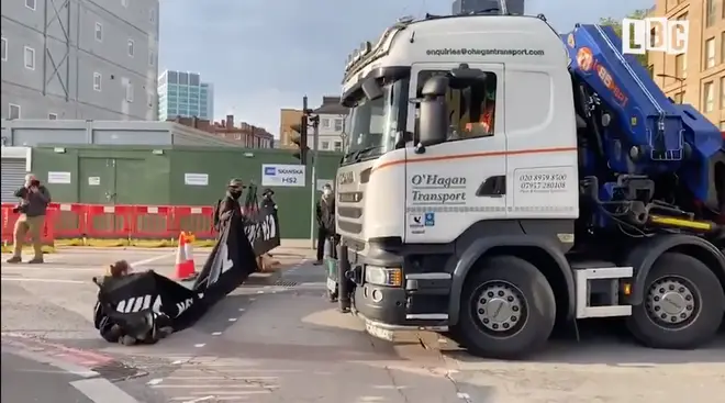 HS2 protesters sit in front of a flat-bed lorry at Euston