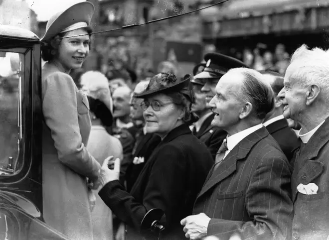 Princess Elizabeth (later Queen Elizabeth II) is greeted by crowds as she tours the East End of London on the day after VE Day