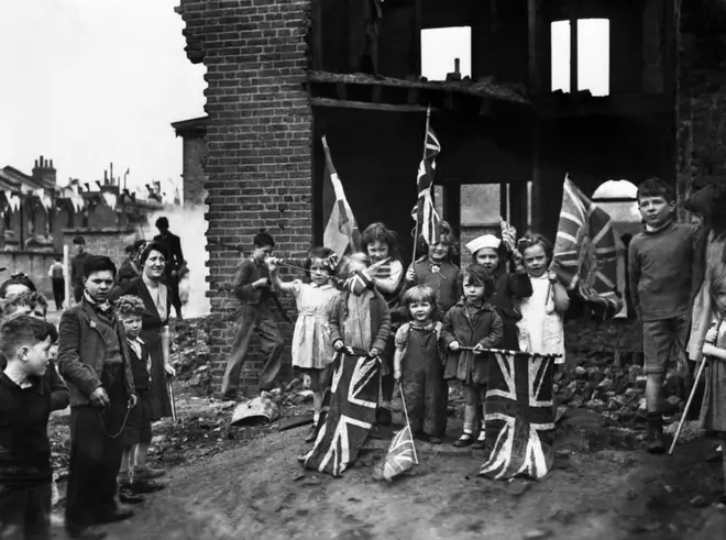 Children in London celebrate within the ruins of their bombed out homes