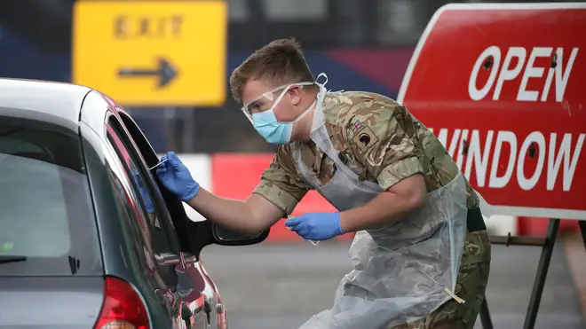 A soldier from 2 Scots Royal Regiment of Scotland take a test sample at a Covid-19 testing centre at Glasgow Airport