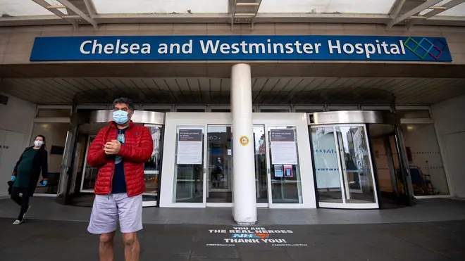 File photo: A man and woman wearing face masks outside the Chelsea and Westminster Hospital in London