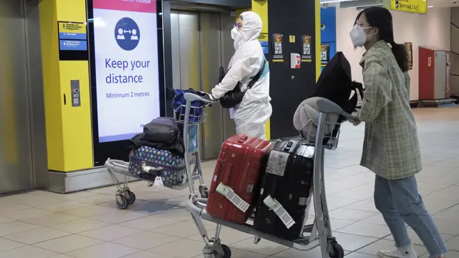 Air passengers in protective gear at Heathrow Airport