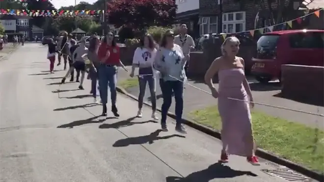 Residents take part in the 'socially distanced' conga line