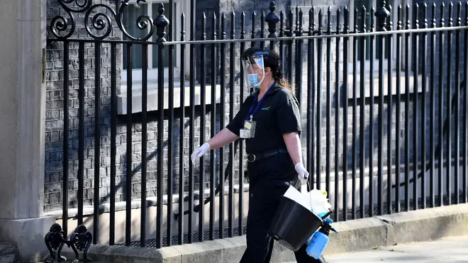 A cleaner in PPE is seen arriving at Downing Street on 16 April
