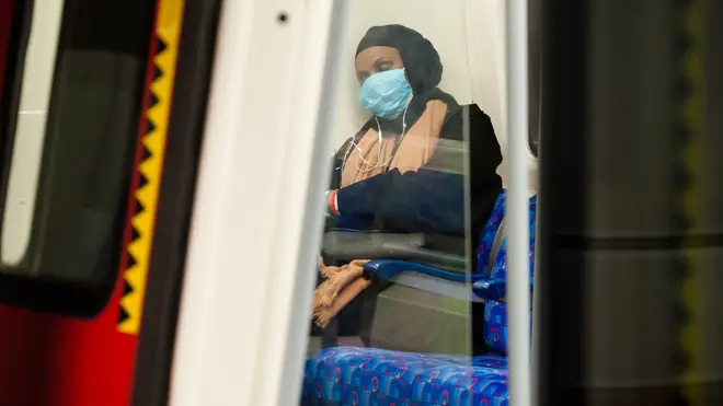 A woman pictured on the Tube in a protective face mask