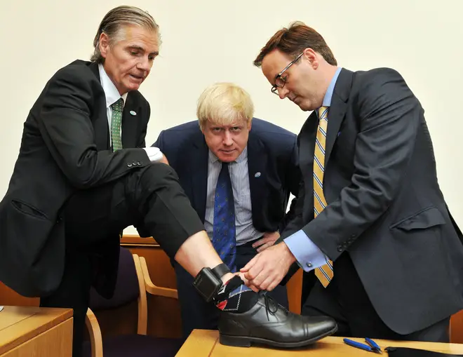 File photo of a sobriety tag being removed as Boris Johnson, at the time the Mayor of London, looks on