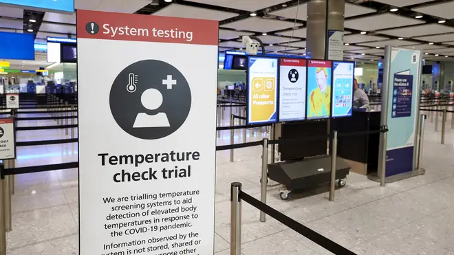Signs informing of temperature screening equipment being trialled at London Heathrow Airport