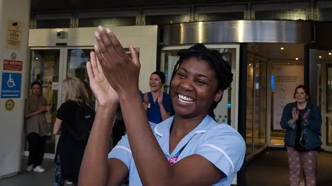 A nurse claps her hands outside Chelsea and Westminster Hospital to take part in the weekly 'clap for our carers' applause