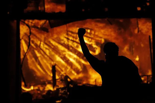 Protesters in front of the police station after it was set ablaze