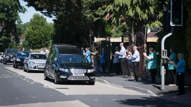 NHS staff and passersby broke into applause as the cortage passed by
