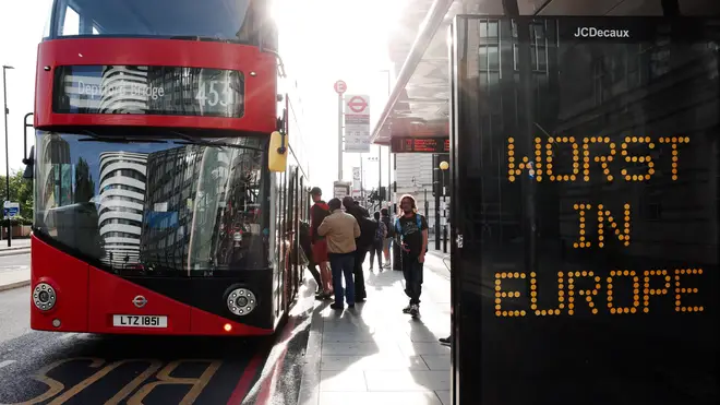 People board a bus at a stop bearing the message 'Worst In Europe'on Westminster Bridge Road in London